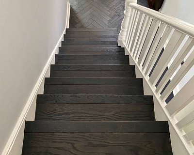 Anthracite oak stair cladding and herringbone floors in London
