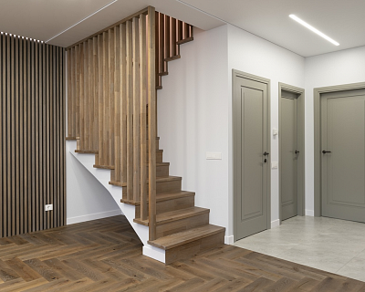 Herringbone oak parquet and oak stairs in the Silver Dust colour, complemented by Art Deco-style oak doors and oak deco walls